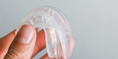 Closeup of patient holding clear mouthguard