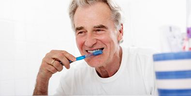 a man brushing his teeth and dental implants