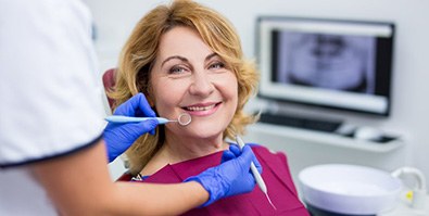 a patient smiling after receiving her dental implant restorations