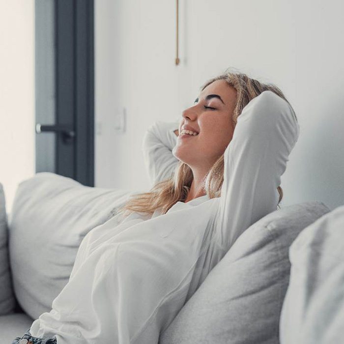 Smiling woman relaxing on couch at home